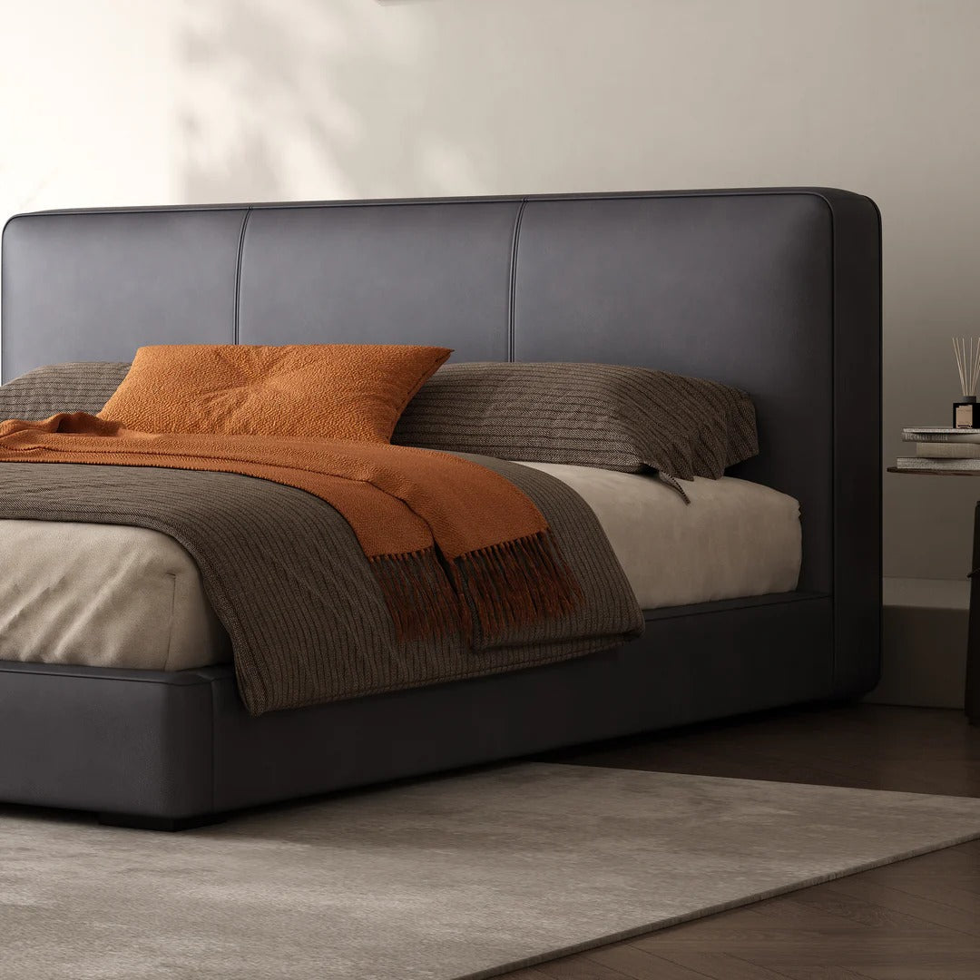 Bed with dark leather headboard